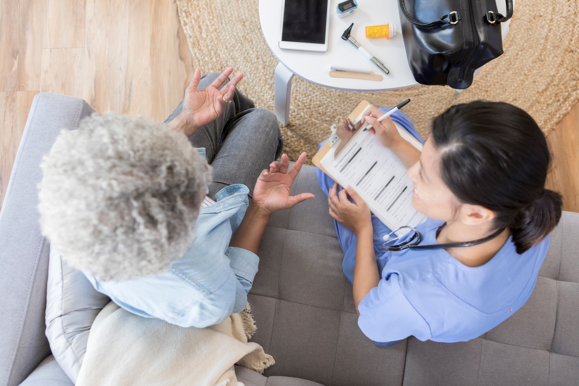 Home health nurse visits senior woman at home